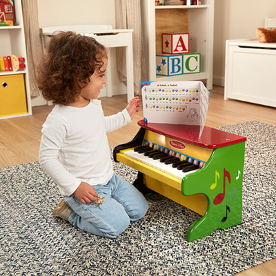 MELISSA & DOUG<sup>&reg;</sup> Learn to Play Piano - Your littlest musician will never want to stop making music with this multi-colored upright piano that features 25-keys and contains two full octaves. Features color-coded and labeled keys. Explore the concepts of high and low notes as well as loud and soft. Recommended for ages 3-6 years and includes color-coded songbook.